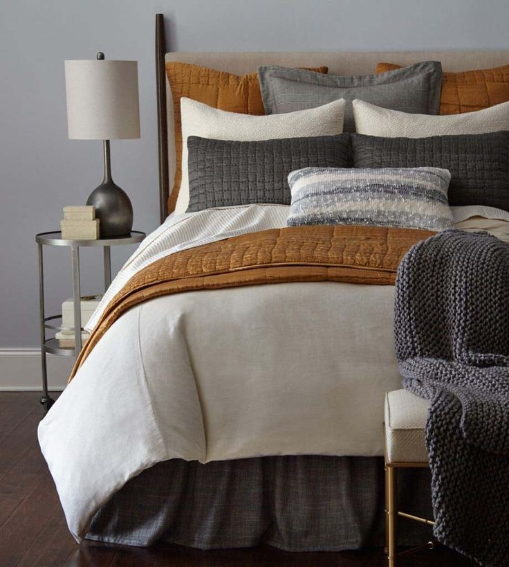 a bedroom with a bed, chair and lamp on the side table in front of it