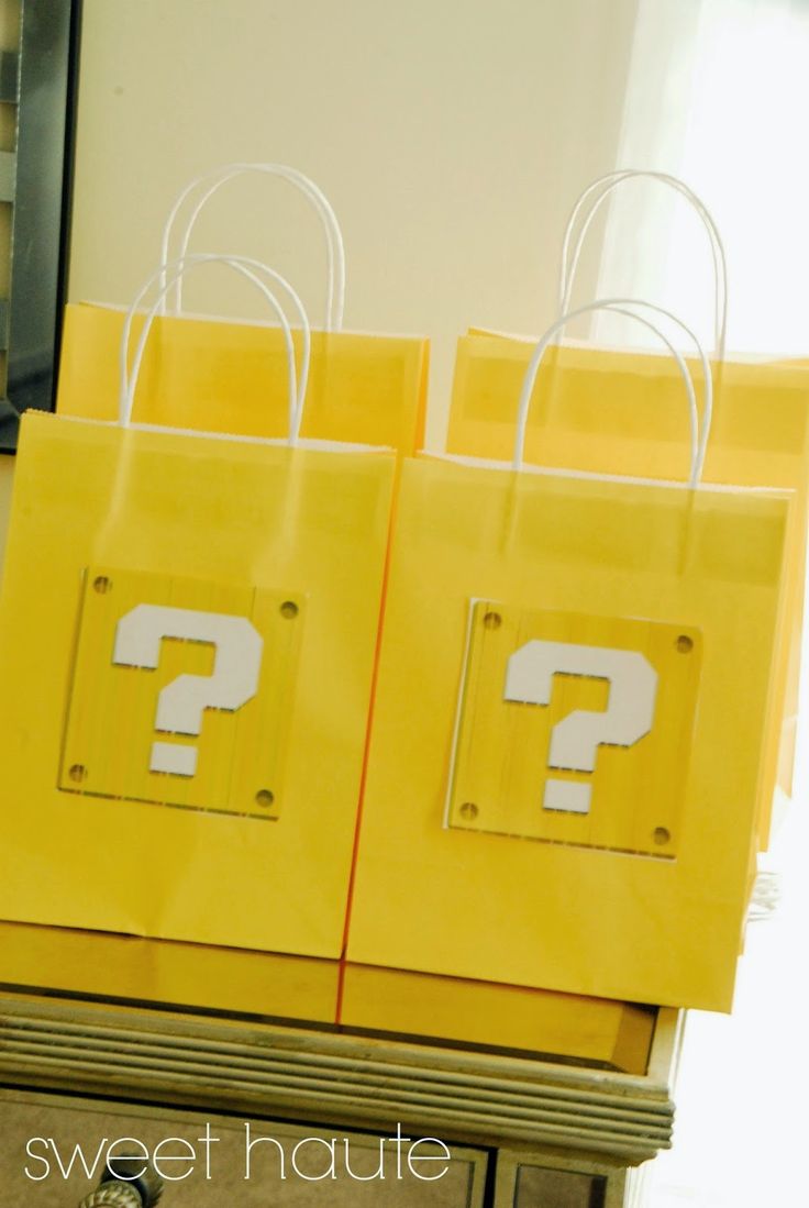 two yellow bags with question marks on them sitting on a table in front of a mirror