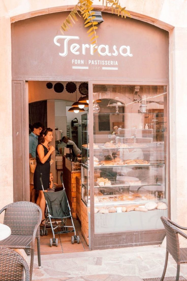 two people standing in front of a pastry shop