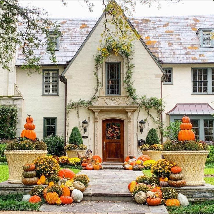 a house with pumpkins and gourds in front of it on instagram