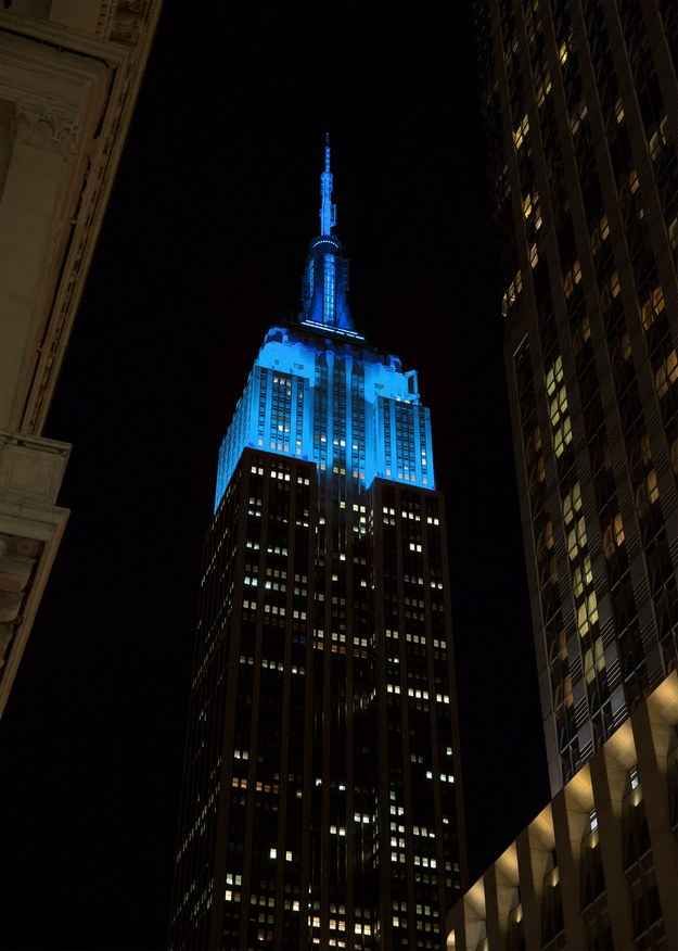 the empire building lit up in blue and white