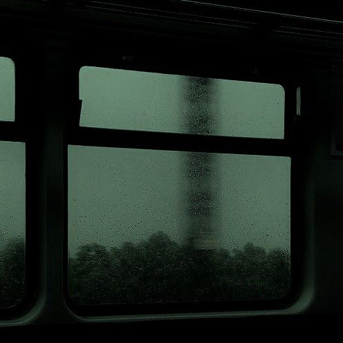 a window with rain drops on it looking out at the eiffel tower