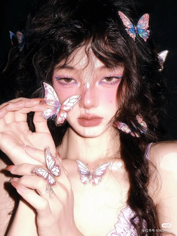 a woman with butterfly wings on her head and hands in front of her face, posing for the camera