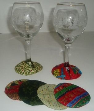 three wine glasses sitting next to each other on a white counter top with cloth covered coasters