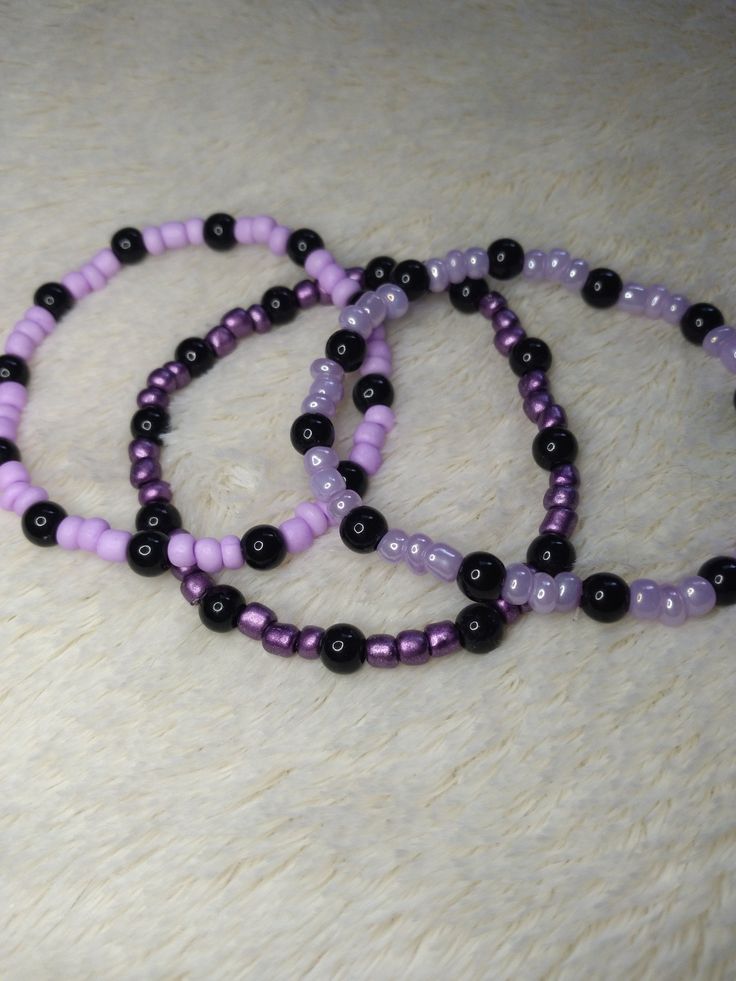 Perfect for a fan of purple!! Lots of purple!! Lightweight and super comfy, these are great for just a casual splash of color to any outfit. Made with glass beads (that's the purple) and plastic (that's the black), they're just cute and fun to have on! Each bracelet CAN vary in size due to the glass beads being variable sizes, but they measure approximately 18-19cms. They are made with .5mm elastic cord and just a little wee touch of jewelry glue to get that knot nice and SECURE! Because we can' Black And Purple Beaded Bracelets, Purple And Black Bracelet, Trendy Black Bracelets With Colorful Beads, Trendy Black Beaded Bracelets, Trendy Black Plastic Bracelets, Handmade Black Plastic Jewelry, Handmade Purple Stretch Bracelet, Casual Purple Bracelets With Colorful Beads, Trendy Purple Plastic Jewelry