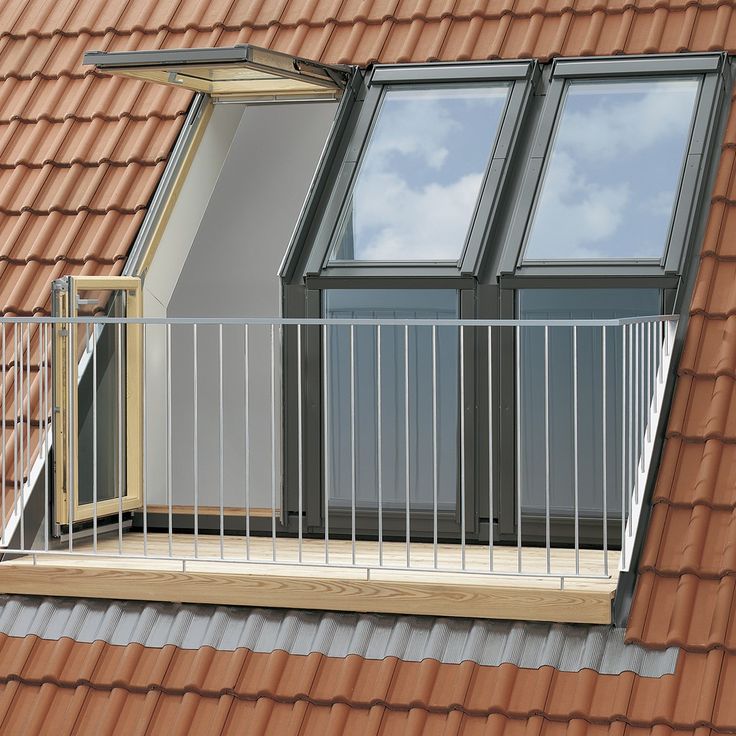 an open window on the side of a red tiled building with a balcony and balconies