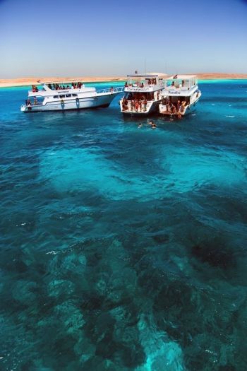 two boats in the water with people on them