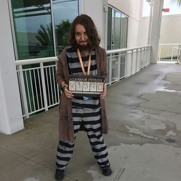 a man dressed in jail clothes holding a sign