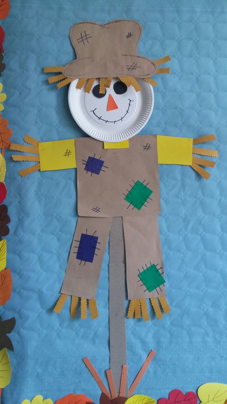 a paper plate scarecrow is displayed on a blue background