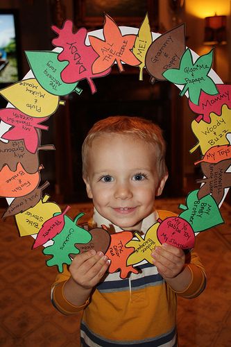 a young boy holding up some cut out hearts