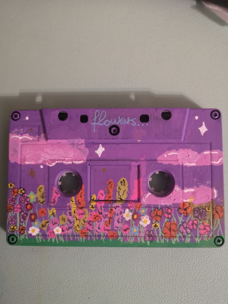 a purple cassette with flowers painted on it