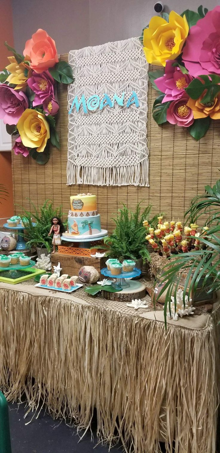 a table topped with lots of food next to a wall covered in flowers and greenery