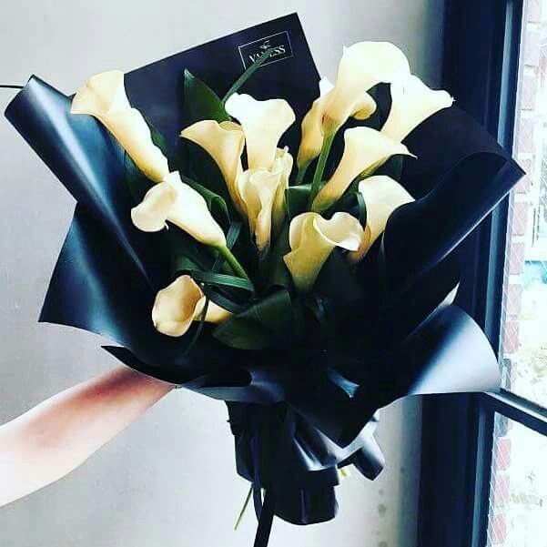 a person holding a bouquet of flowers near a window