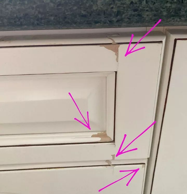 the kitchen cabinets have been painted white with pink arrows pointing up at it's center