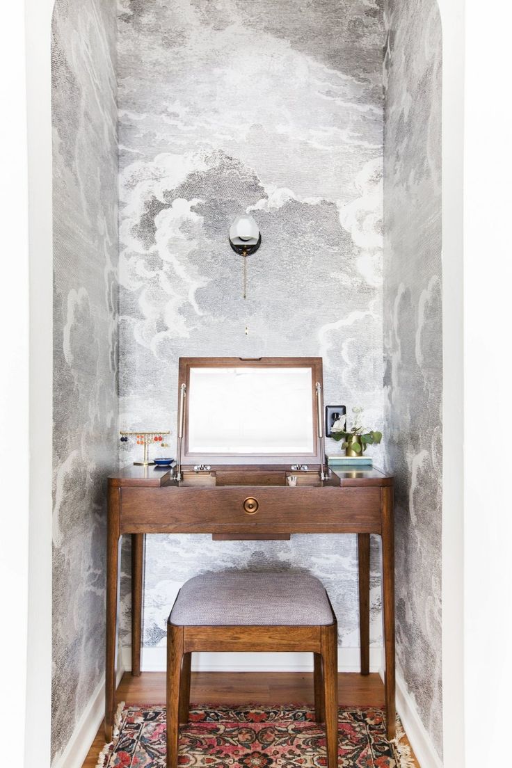 a dressing table with a mirror and stool in a room that looks like it has been painted