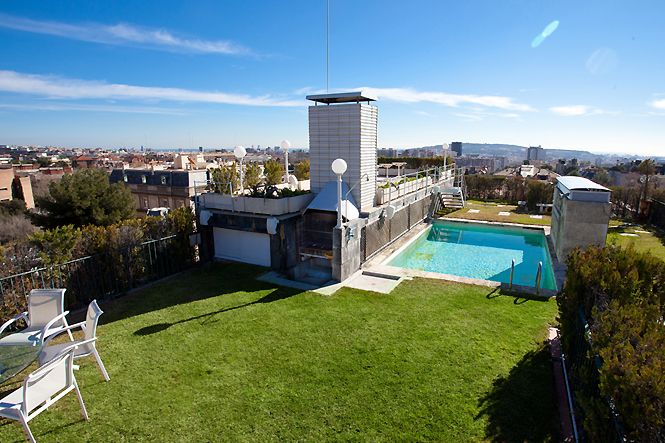 an aerial view of a house with a swimming pool in the yard and lawn area