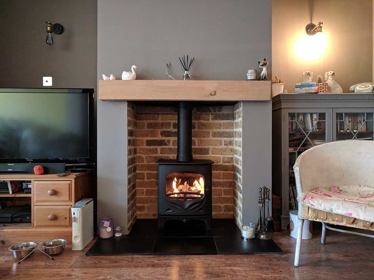 a living room filled with furniture and a fire place in the middle of the room