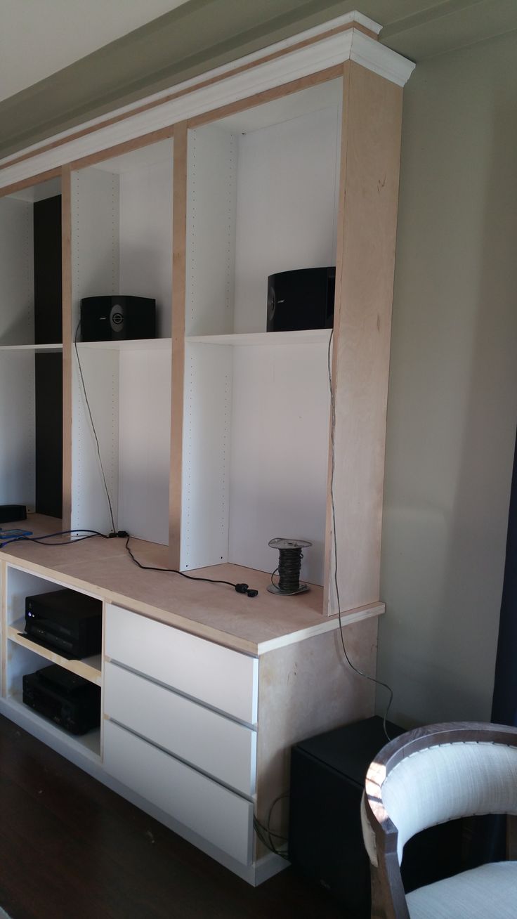 a living room with white furniture and wood flooring on the walls, along with an entertainment center