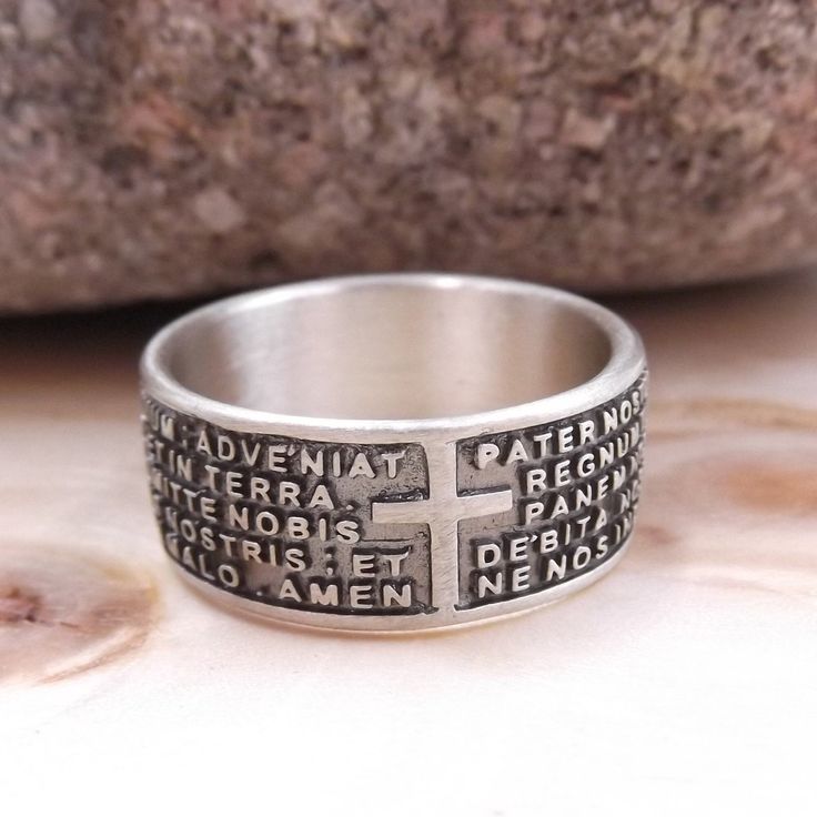 "Band ring with engraved prayer \"Our Father\" in Latin Features Material: silver Metal title: 925 Weight: gr. 7,50 Engraved prayer: Our Father in Latin Warranty: Gioielli Aurum Color: silver Subject: New Product code: aneb128_arg Various sizes available. Hypoallergenic - DOES NOT darken. The Jewel is new and is shipped insured by express courier, in gift box with warranty included. All our jewels are punched with the precious metals brand and the trademark. Watch the video of this ring at: http Spiritual White Gold Ring Stamped 925, Symbolic Engraved Ring Stamped 925 For Promise, Sterling Silver Cross Ring For Promise, Engraved Silver Spiritual Rings, Symbolic Silver Ring For Commemoration, Spiritual Engraved Silver Rings, Silver Cross Rings Stamped 925, Spiritual Cross Shaped Rings For Gift, Silver Hallmarked Rings For Commemoration