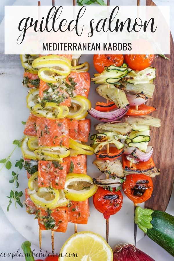 grilled salmon and vegetable kabobs on skewers with lemon wedges