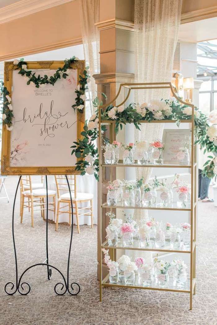 a sign that says bride's shower next to a display case with flowers on it