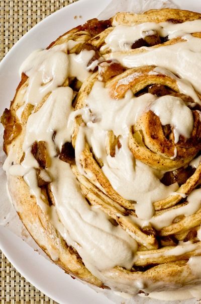 a white plate topped with cinnamon rolls covered in icing