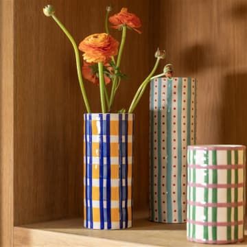 two vases with flowers in them sitting on a shelf next to each other,