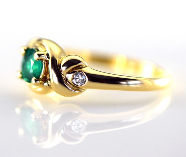 A lovely Columbian Emerald accented with two sparkling diamonds in a 14k yellow gold ring. The emerald is a 5 mm round and weighs .50 carats and is a genuine emerald from Columbia. The two diamonds are round brilliants with a total weight of .08 carats G-H color VS2 clarity The metal is 14k yellow gold and the ring is 8.4m wide at the stone Ring weight 4.45 grams Size 7 3/4 Jewelry from Stowe Gems arrives beautifully packaged in a gift box. If you have any questions about this piece or if we can Elegant Three-stone Birthstone Ring In 14k Gold, Elegant Three Stone Birthstone Ring In 14k Gold, Timeless Emerald Anniversary Ring, Timeless Emerald Wedding Anniversary Ring, Elegant Emerald Three-stone Birthstone Ring, Elegant Gold Three-stone Birthstone Ring, Elegant Three Stone Diamond Birthstone Ring, Elegant Three Stone Birthstone Ring For Formal Occasions, Elegant Gold Three Stone Birthstone Ring