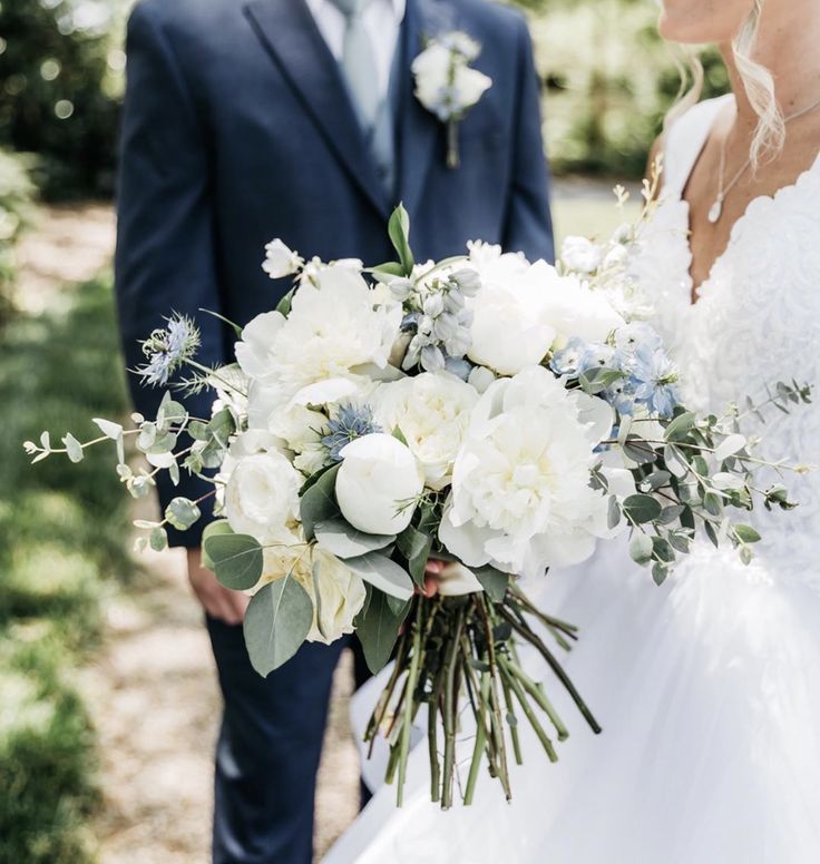 the bride and groom are holding their bouquets