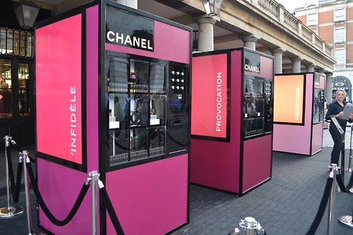 a row of pink and black vending machines in front of a building