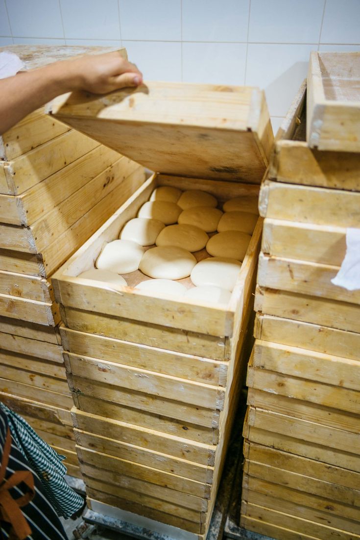 stacks of wooden pallets stacked on top of each other in front of a person