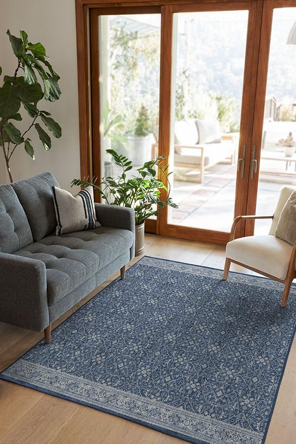 a living room filled with furniture and a blue rug