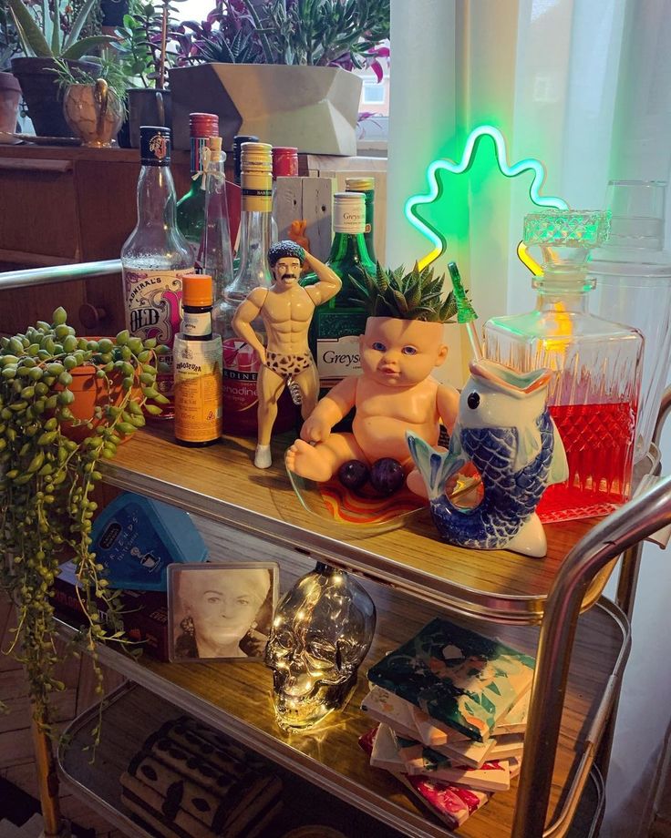 a bar cart with various bottles and figurines on it