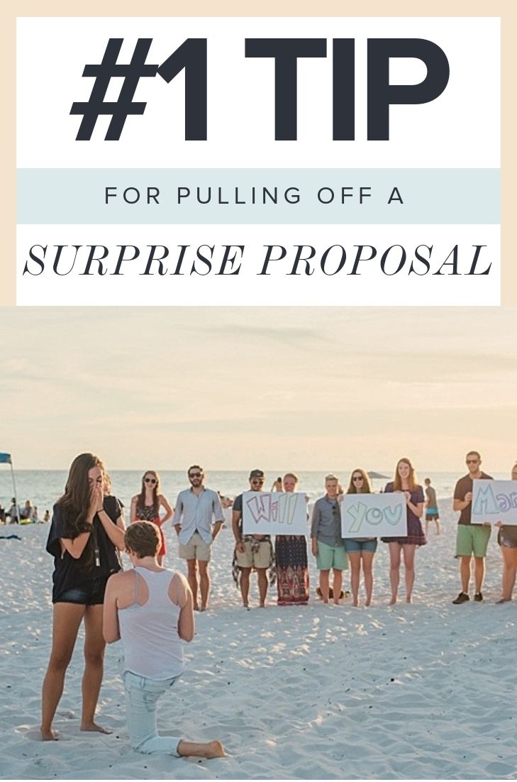 a group of people standing on top of a beach next to the ocean holding up signs