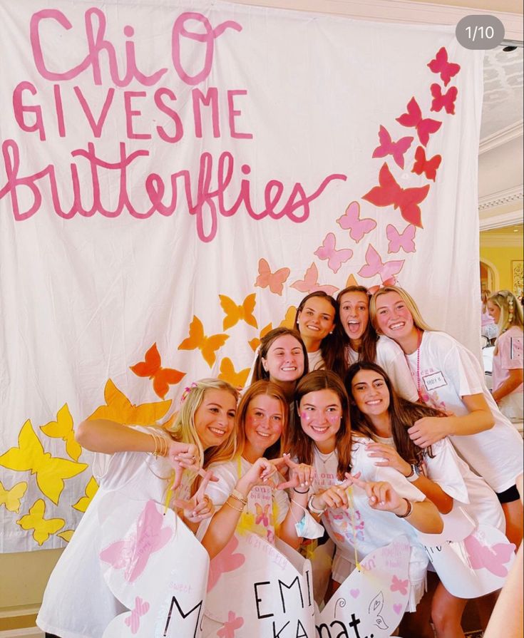 a group of girls posing in front of a sign that says chiqui gives me butterflies