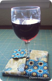 a glass of wine sitting on top of a table next to a cloth covered napkin