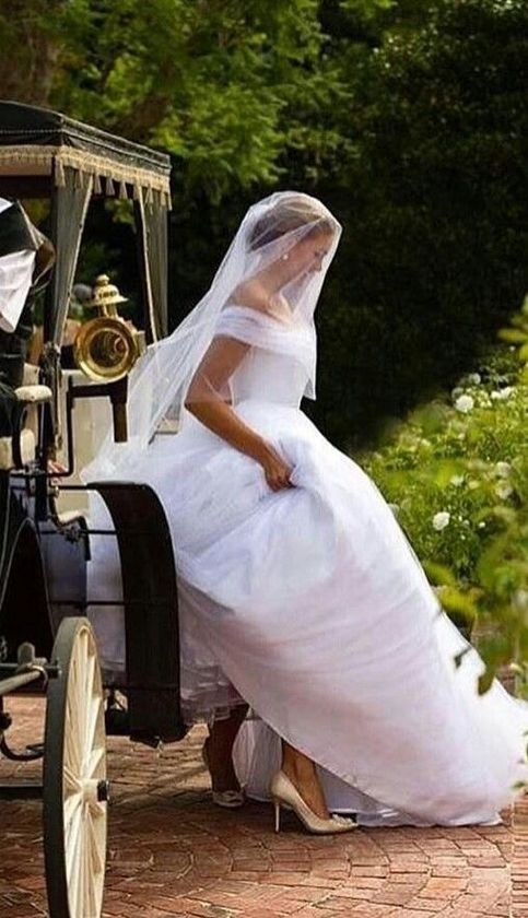 a woman in a wedding dress sitting on a horse drawn carriage next to a man in a tuxedo