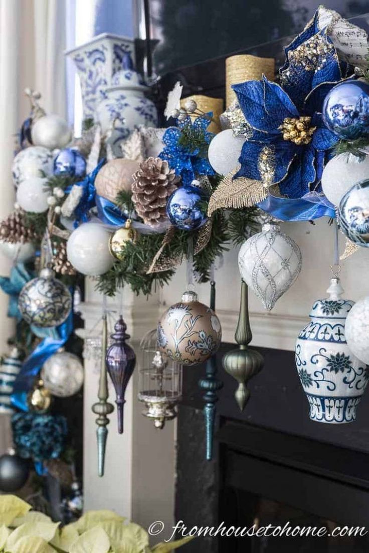 blue and white ornaments are hanging on the fireplace mantel