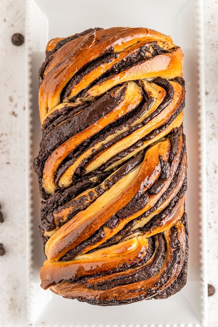 a loaf of chocolate swirled bread on a white plate