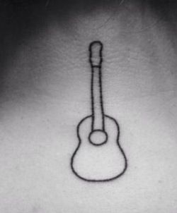 a black and white photo of a guitar tattoo