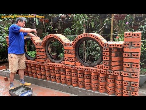 a man standing next to a pile of orange bricks