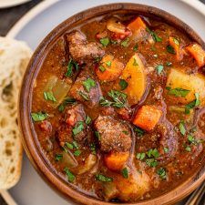 a bowl of stew with bread on the side