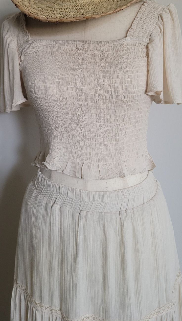 Elevate your summer style with our Woven Skirt Set in White! The crop top features a flattering square neckline and smocking for a perfect fit, while the flowy sleeves and ruffle detail add a touch of charm. The midi skirt has an elastic waistband and lace trim for a feminine touch, and is fully lined for comfort. Made of 100% rayon and 100% polyester lining. Model is 5'8" and wearing a size Small. Fit: True to size Pockets Skirt lined Rayon Summer Ruched Square Neck Crop Top, Square Neck Crop Top For Spring Vacation, Fitted Smocked Summer Top With Elastic Waistband, Fitted Smocked Top With Elastic Waistband For Summer, Flowy Smocked Top For Day Out, Summer Short Sleeve Crop Top With Smocked Bodice, Chic Fitted Crop Top With Elastic Waistband, Spring Ruffled Square Neck Crop Top, Chic Spring Crop Top With Elastic Waistband