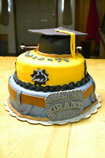 a yellow graduation cake on a wooden table