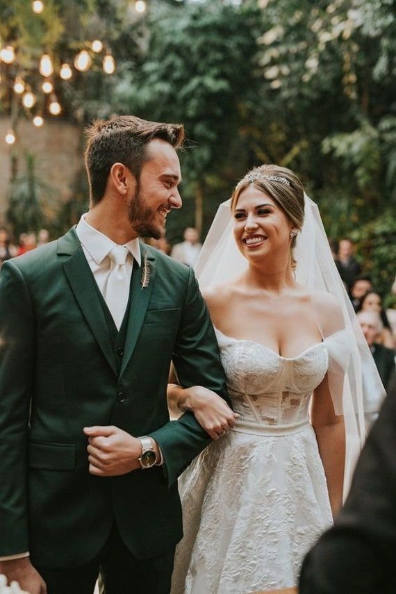 a bride and groom smile as they walk down the aisle