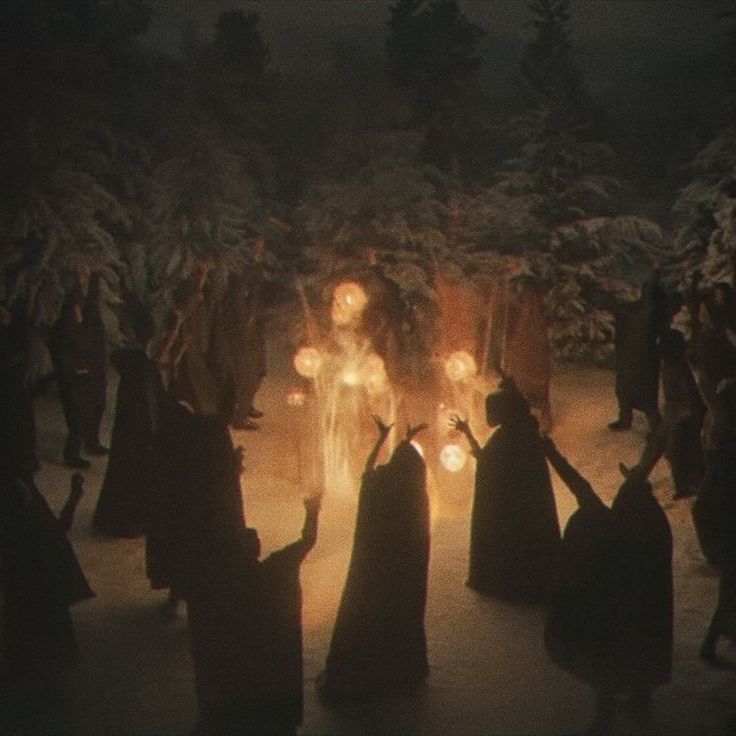 a group of people dressed in black holding torches