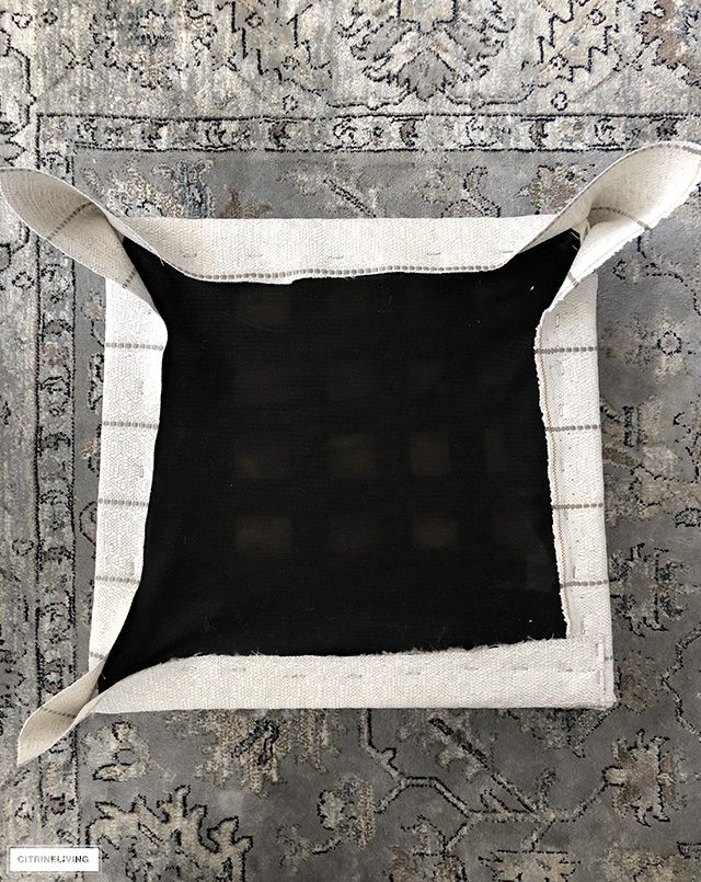 a black and white pillow sitting on top of a rug