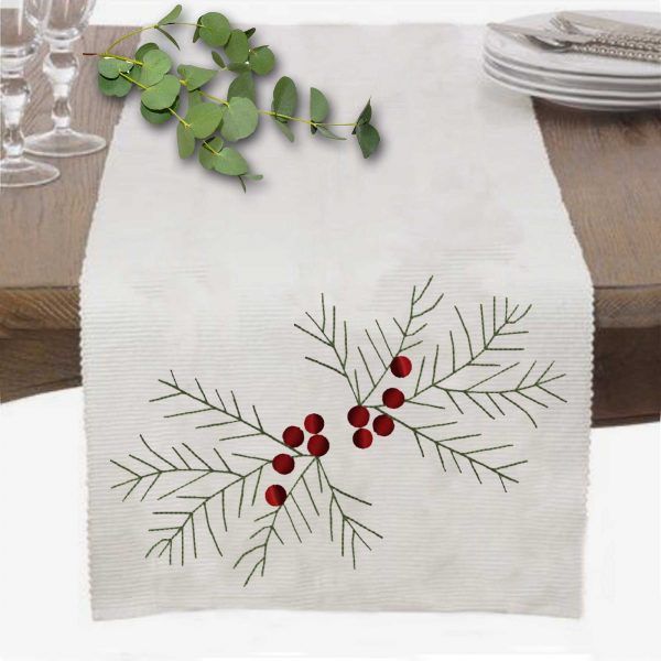 a white table runner with red berries and green leaves on it next to wine glasses