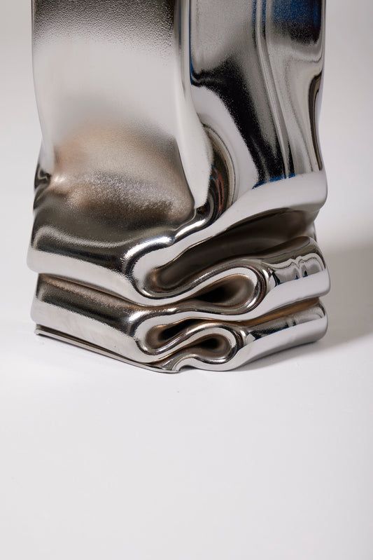 a stack of silver objects sitting on top of a white table