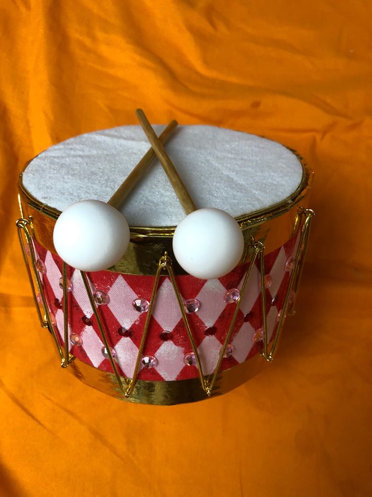 a close up of a drum with two balls on it and sticks sticking out of the top